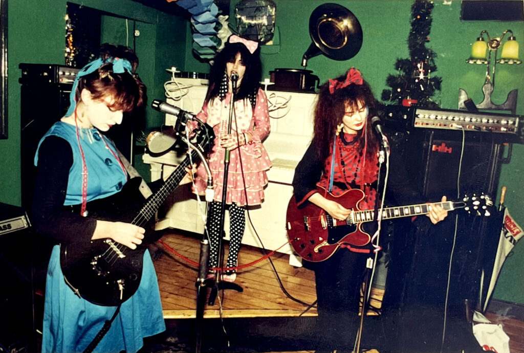 First ever Strawberry Switchblade gig, Spaghetti Factory, Glasgow, December 1981. Janice Goodlett (bass), Rose McDowall (vocals), Jill Bryson (guitar). The stage was only big enough for Rose! Pic used by kind permission of Peter Anthony McArthur, who retains copyright.